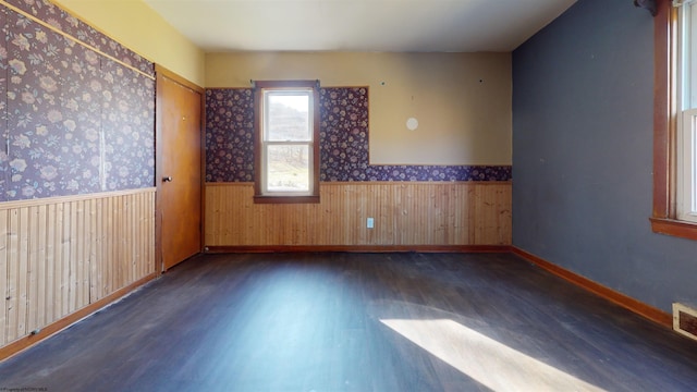 unfurnished room with dark hardwood / wood-style floors and wood walls