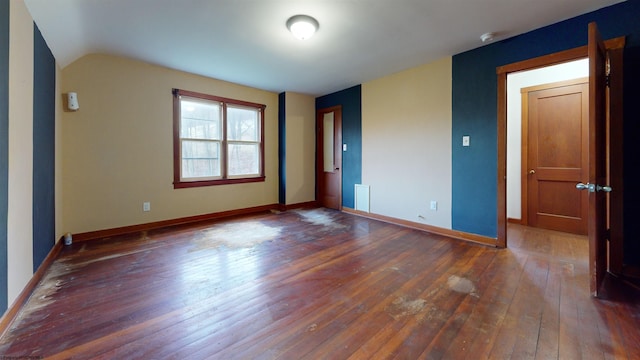 unfurnished bedroom featuring vaulted ceiling and dark hardwood / wood-style flooring