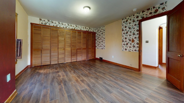 unfurnished bedroom featuring dark hardwood / wood-style flooring and a closet