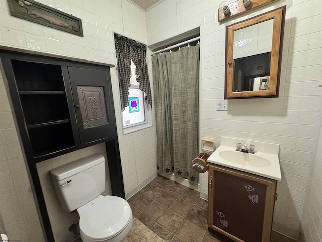 bathroom with vanity, tile walls, and toilet