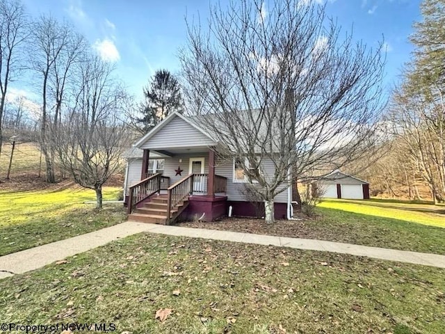 view of front of house with a garage, an outdoor structure, a front yard, and a porch