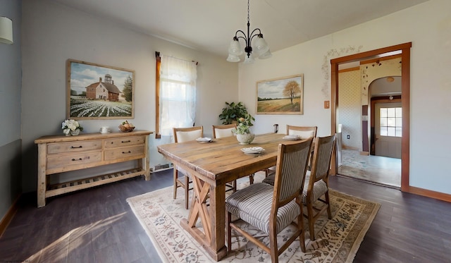 dining area with dark hardwood / wood-style floors and a chandelier