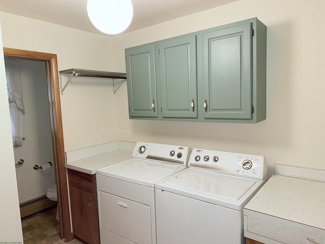 laundry area featuring baseboard heating, cabinets, and washing machine and dryer