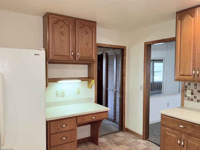 kitchen featuring white fridge and decorative backsplash