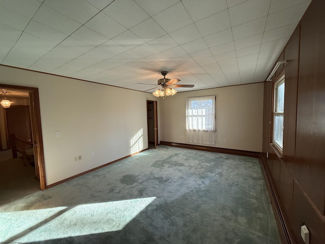 spare room with ceiling fan, ornamental molding, and carpet floors