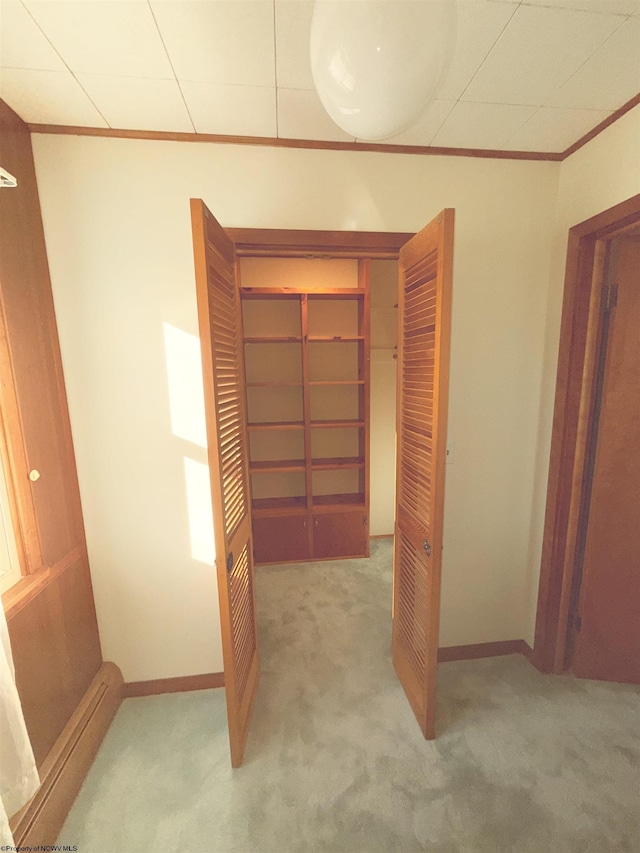 interior space featuring ornamental molding and light carpet