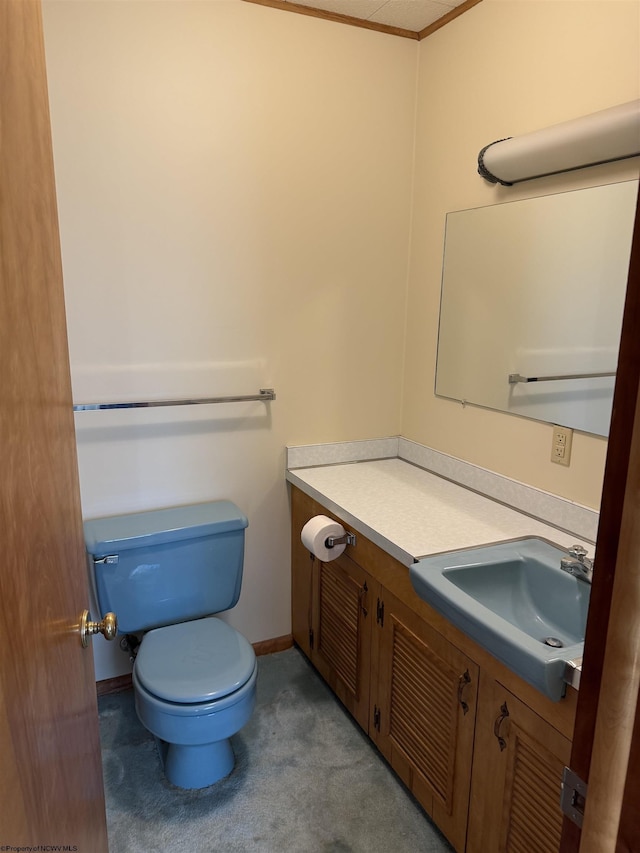 bathroom featuring vanity, crown molding, and toilet