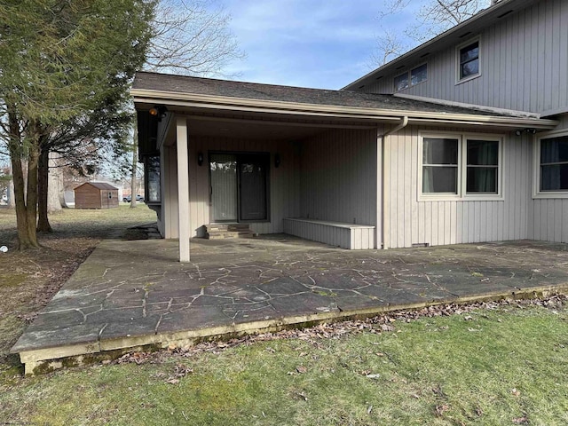 entrance to property with a yard and a patio area