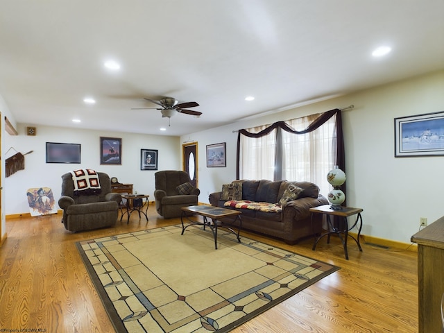 living room with wood-type flooring and ceiling fan