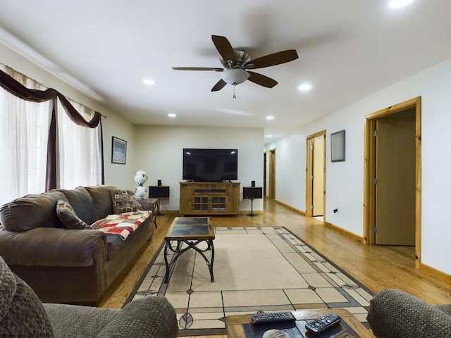 living room featuring ceiling fan and light hardwood / wood-style flooring