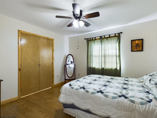 bedroom featuring dark wood-type flooring, a closet, and ceiling fan