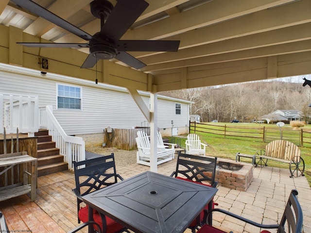 view of patio featuring a wooden deck, ceiling fan, and an outdoor fire pit