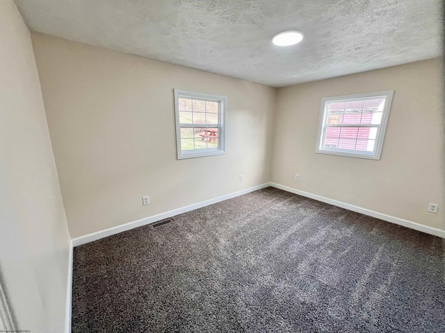 empty room with a textured ceiling and carpet