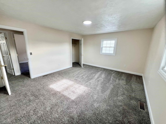 unfurnished bedroom featuring a closet and dark colored carpet