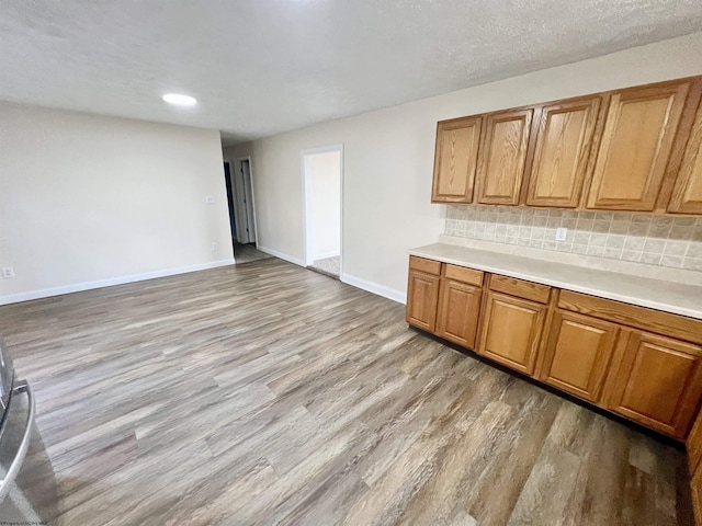 kitchen with tasteful backsplash and light hardwood / wood-style flooring