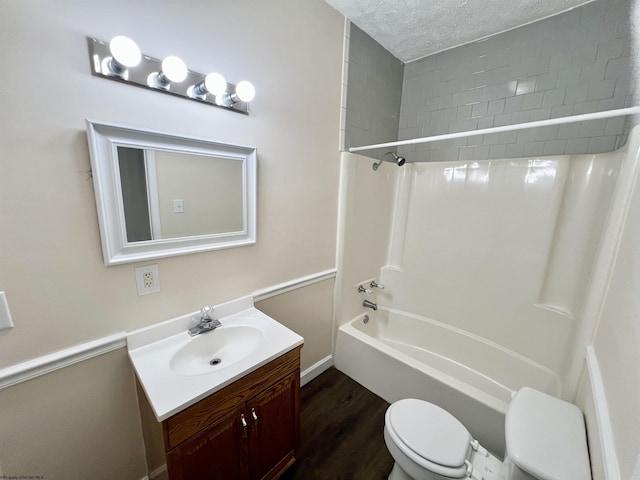 full bathroom featuring hardwood / wood-style floors, shower / bathing tub combination, vanity, toilet, and a textured ceiling