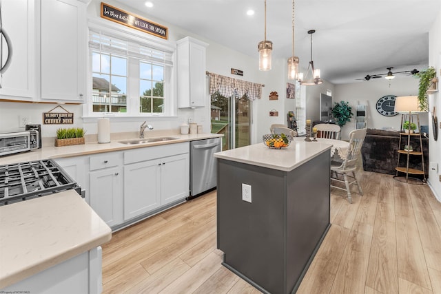 kitchen featuring white cabinetry, a center island, dishwasher, and sink