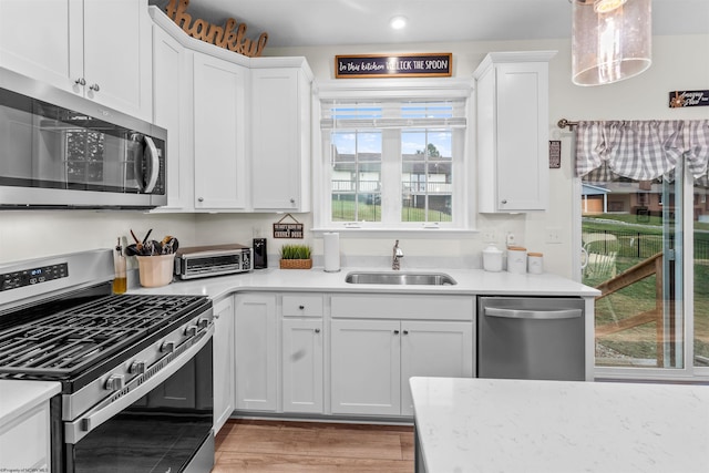 kitchen with white cabinetry, stainless steel appliances, and sink