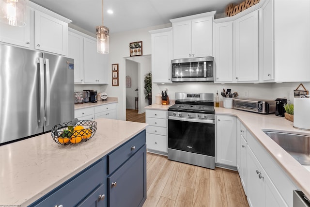 kitchen featuring blue cabinetry, white cabinetry, and stainless steel appliances