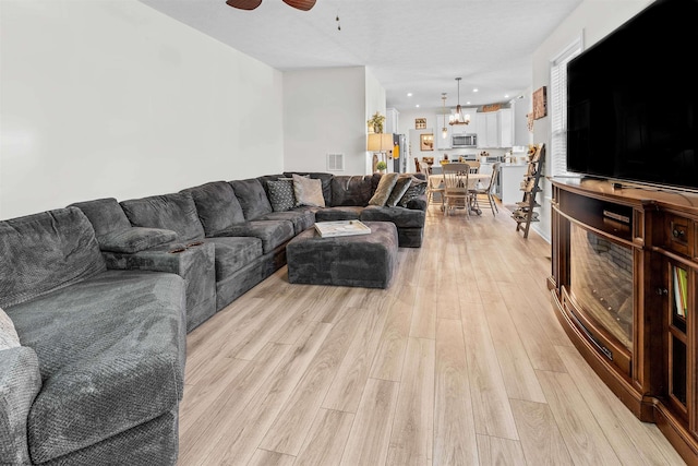 living room with ceiling fan and light hardwood / wood-style floors