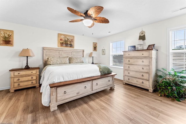 bedroom with ceiling fan, light hardwood / wood-style floors, and multiple windows