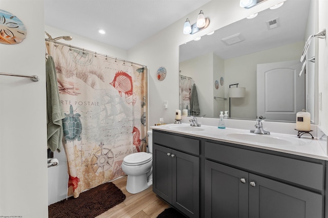 bathroom with hardwood / wood-style flooring, vanity, and toilet