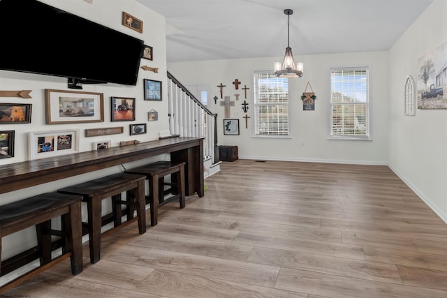 dining area featuring an inviting chandelier and light hardwood / wood-style floors