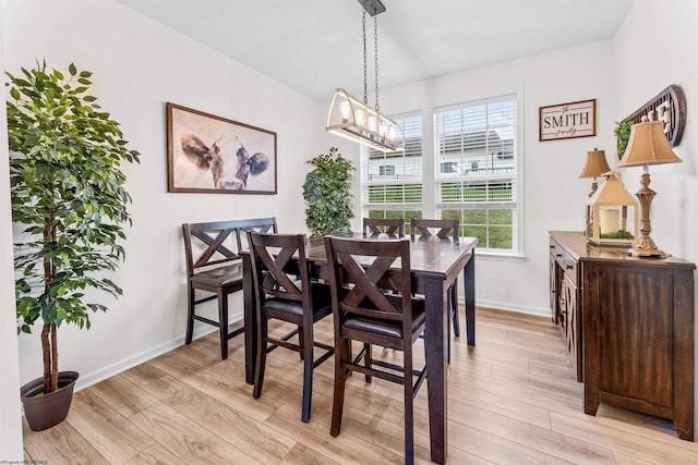 dining room with light hardwood / wood-style floors and a notable chandelier