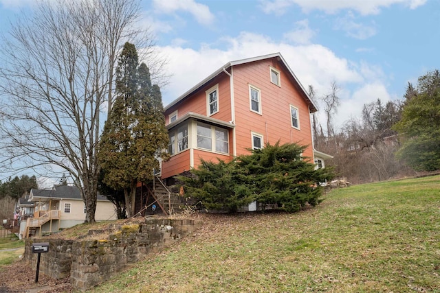 view of property exterior featuring a sunroom and a yard