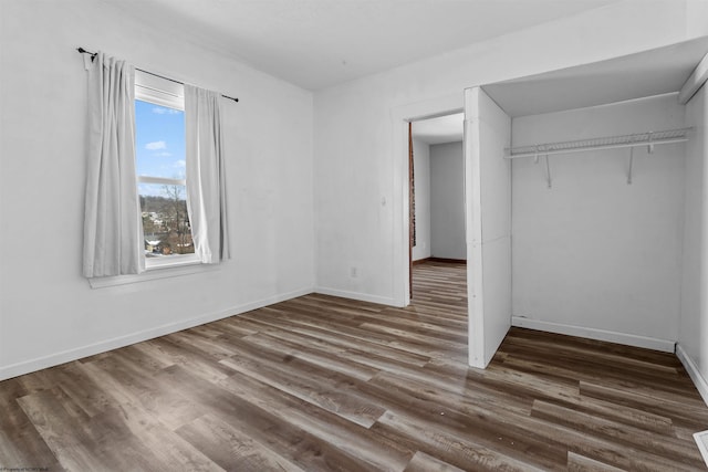 unfurnished bedroom with dark hardwood / wood-style floors and a closet