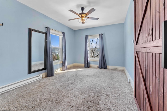 carpeted empty room with a baseboard heating unit and ceiling fan