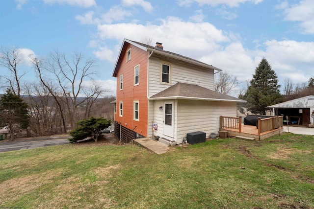 back of house featuring a wooden deck and a lawn