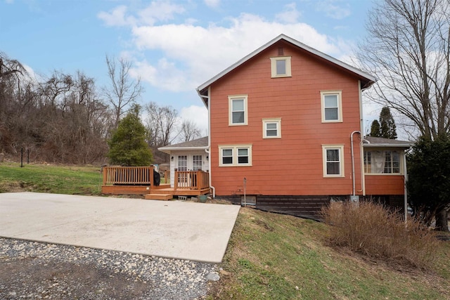 rear view of property with a yard and a deck