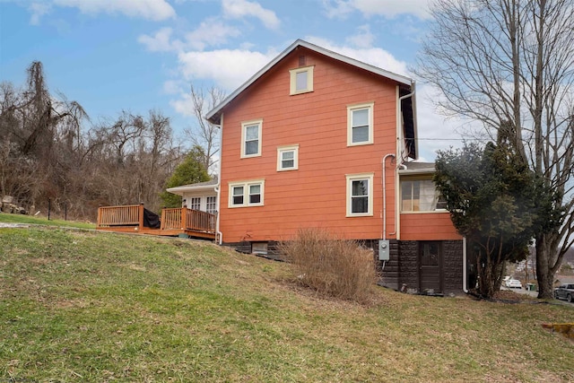 view of home's exterior featuring a wooden deck and a lawn