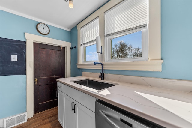 kitchen featuring dark wood-type flooring, sink, white cabinetry, light stone counters, and dishwasher