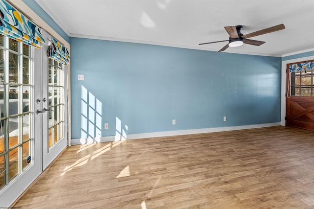 spare room with crown molding, ceiling fan, hardwood / wood-style floors, and a wealth of natural light