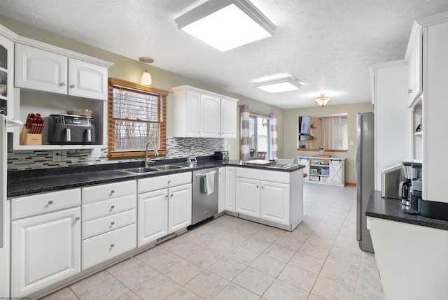 kitchen featuring white cabinetry, stainless steel appliances, kitchen peninsula, and sink