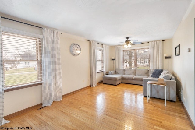 living room with ceiling fan and light hardwood / wood-style flooring