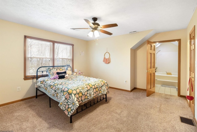 carpeted bedroom featuring ceiling fan, a textured ceiling, and ensuite bathroom