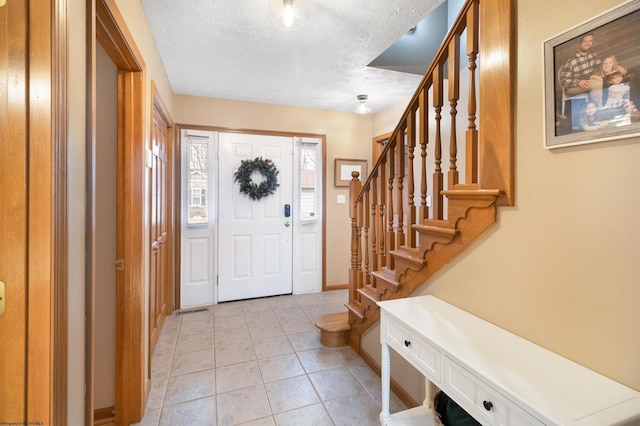 tiled foyer with a textured ceiling