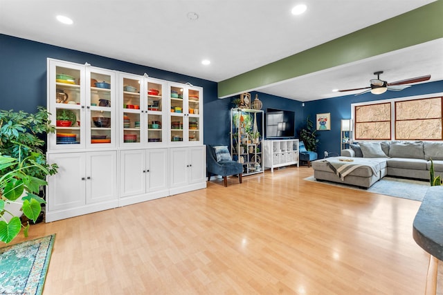 living room with light hardwood / wood-style flooring and ceiling fan