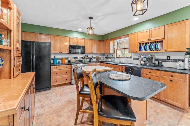 kitchen featuring pendant lighting, tasteful backsplash, black appliances, and a center island