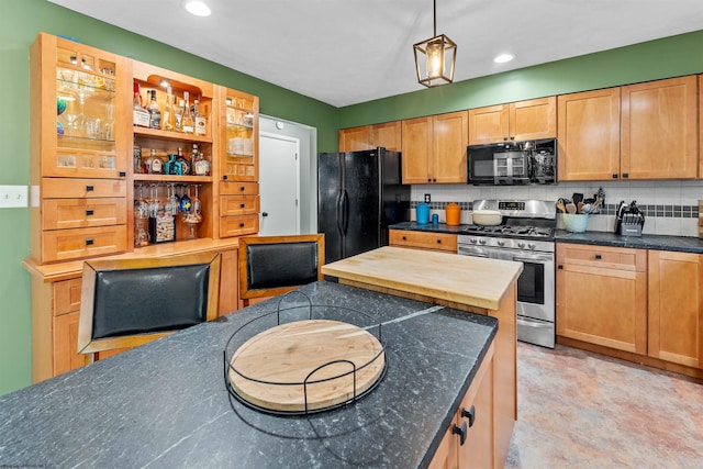 kitchen featuring hanging light fixtures, decorative backsplash, black appliances, and a kitchen island