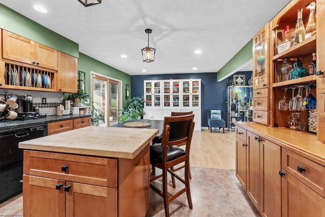 kitchen featuring wood counters, a breakfast bar area, decorative light fixtures, dishwasher, and a kitchen island