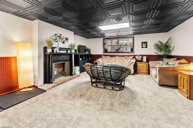 carpeted living room with a fireplace and wood walls