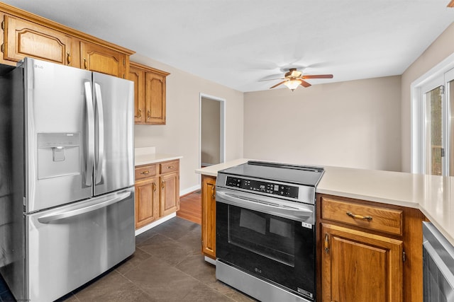 kitchen with ceiling fan, appliances with stainless steel finishes, beverage cooler, and dark tile patterned floors