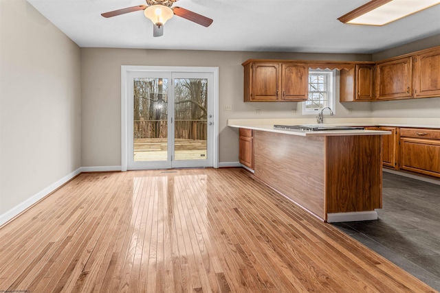 kitchen featuring ceiling fan, light hardwood / wood-style floors, and kitchen peninsula