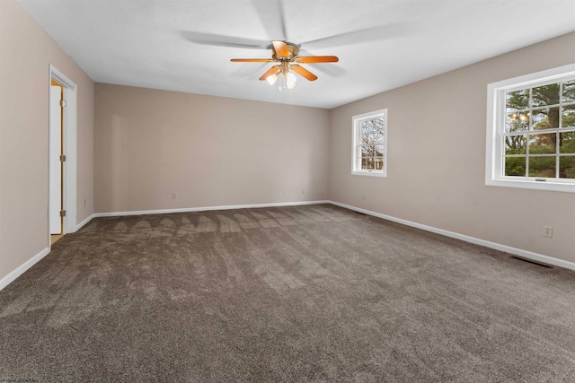 unfurnished room with ceiling fan and dark colored carpet