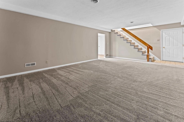 unfurnished living room featuring carpet flooring and a textured ceiling