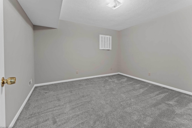 unfurnished room with carpet flooring and a textured ceiling